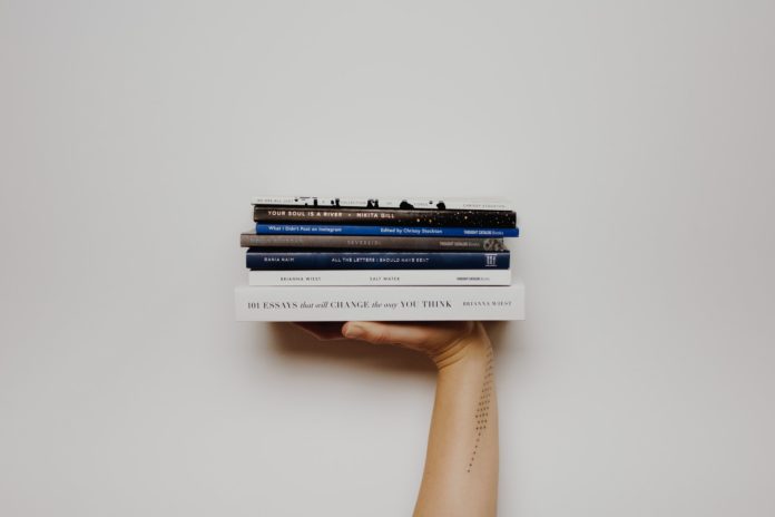 person holding pile of books